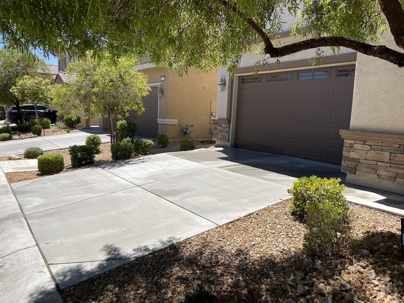 Clean residential driveway in front of a home with a brown garage door