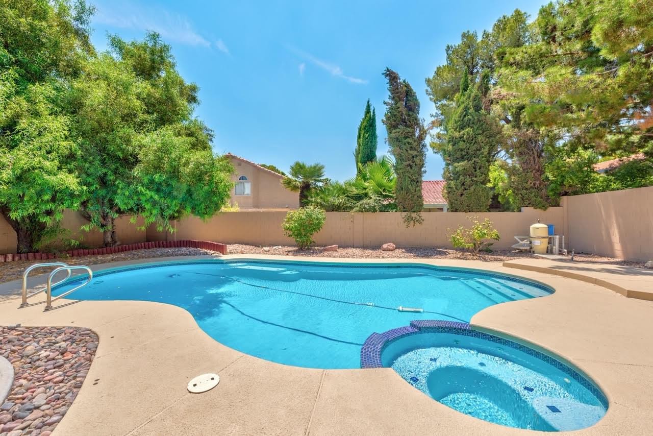 Clean backyard swimming pool and spa with a freshly washed surrounding deck